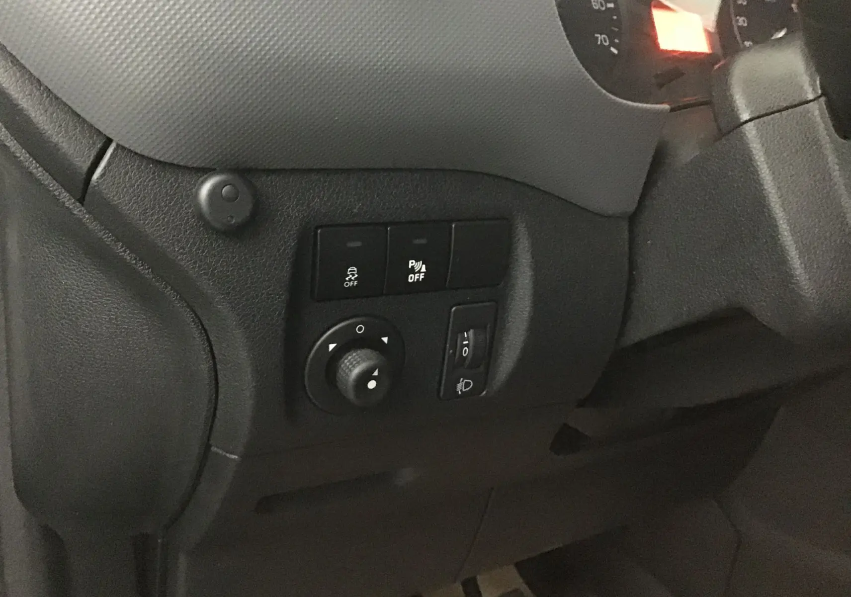 Gros plan sur les commandes noires du tableau de bord côté gauche d'un Citroën Berlingo blanc de 2018.