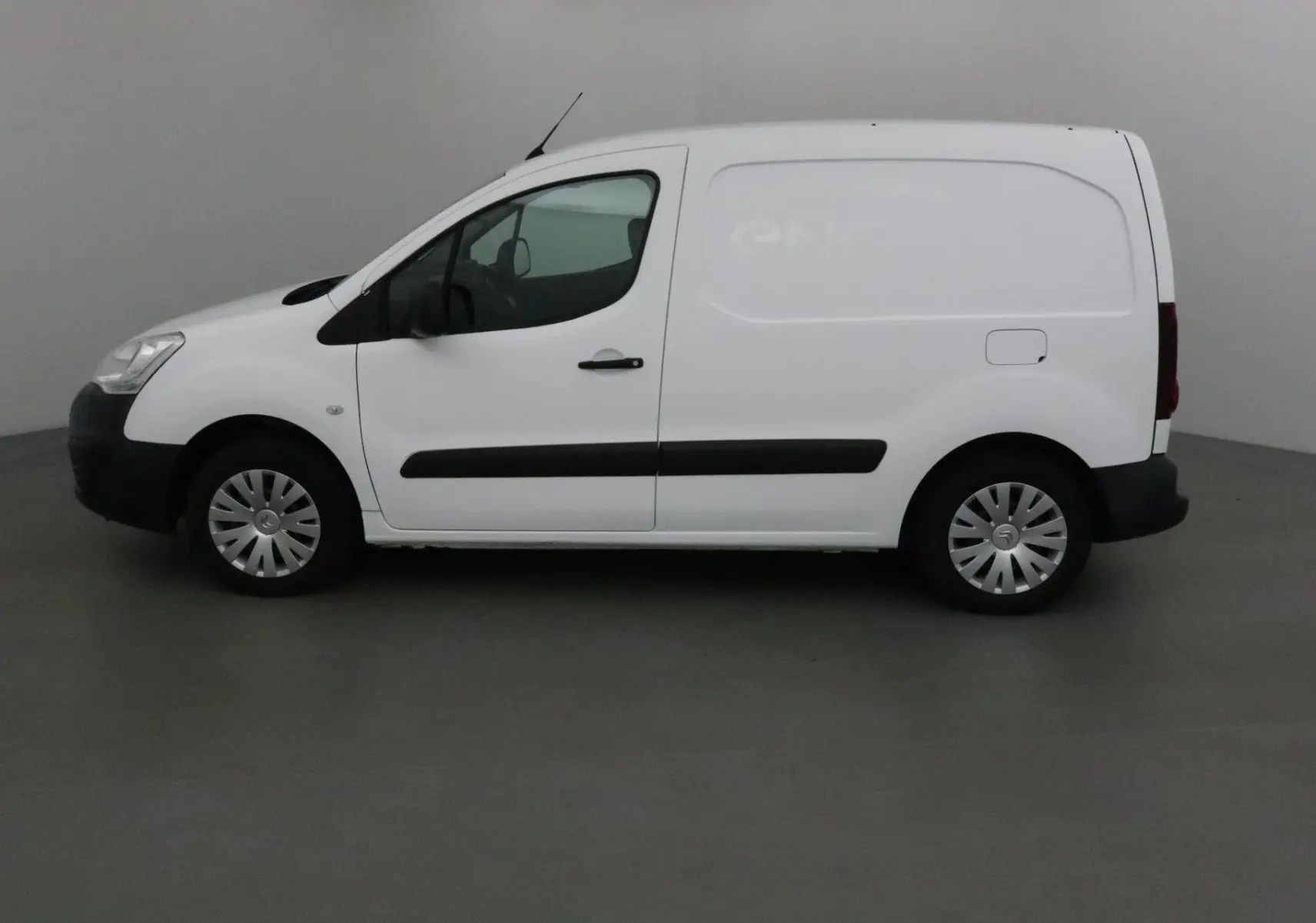 Profil latéral droit d’un utilitaire Citroën Berlingo blanc, version Business 2018, avec protections noires sur les portières.
