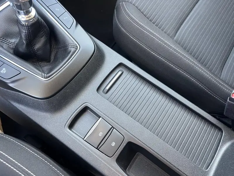 Gros plan sur la console centrale noire avec levier de vitesse manuel et accoudoir tissu noir dans un Ford Kuga 2.0 EcoBlue 2021.