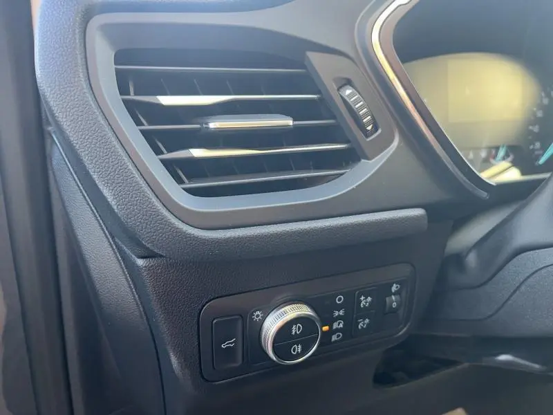 Détail du tableau de bord côté gauche du Ford Kuga 2021 avec commande des phares et sortie d'air noire.