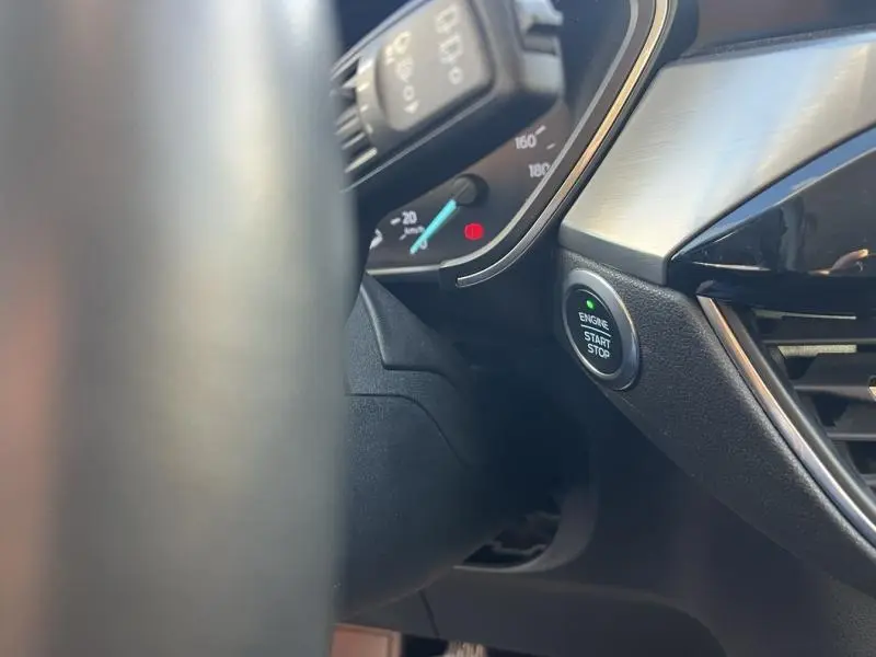 Détail intérieur du tableau de bord du Ford Kuga 2021, bouton start/stop et partie du compteur de vitesse.