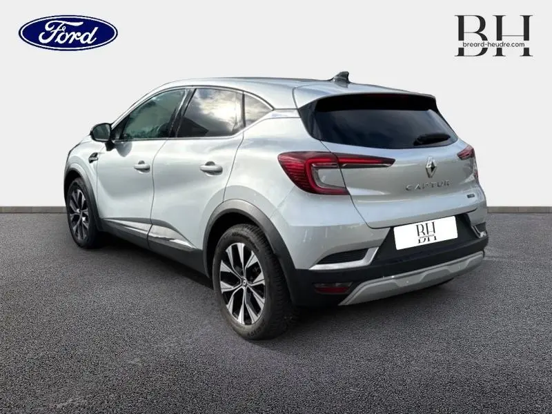 Vue 3/4 arrière droite d'un Renault Captur gris clair avec feux arrière LED et jantes alliage noires.