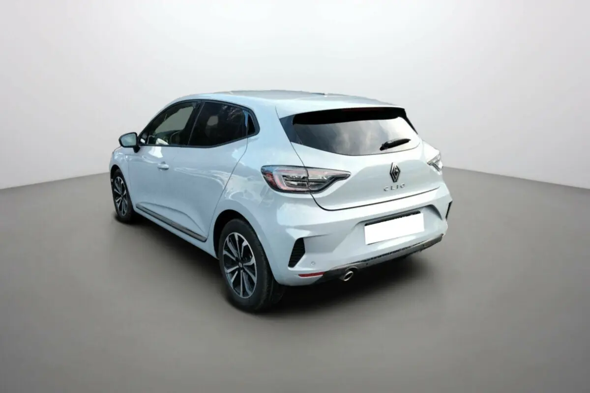 Vue 3/4 arrière droite d'une Renault Clio gris clair avec vitres surteintées et jantes alliage noir.