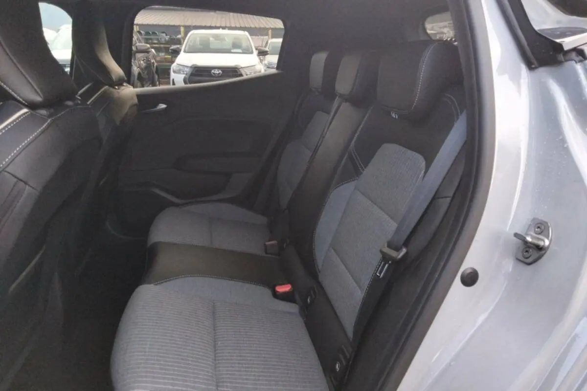 Vue intérieure côté droit sur la banquette arrière gris clair et noir de la Renault Clio 2025 avec ceinture de sécurité visible.