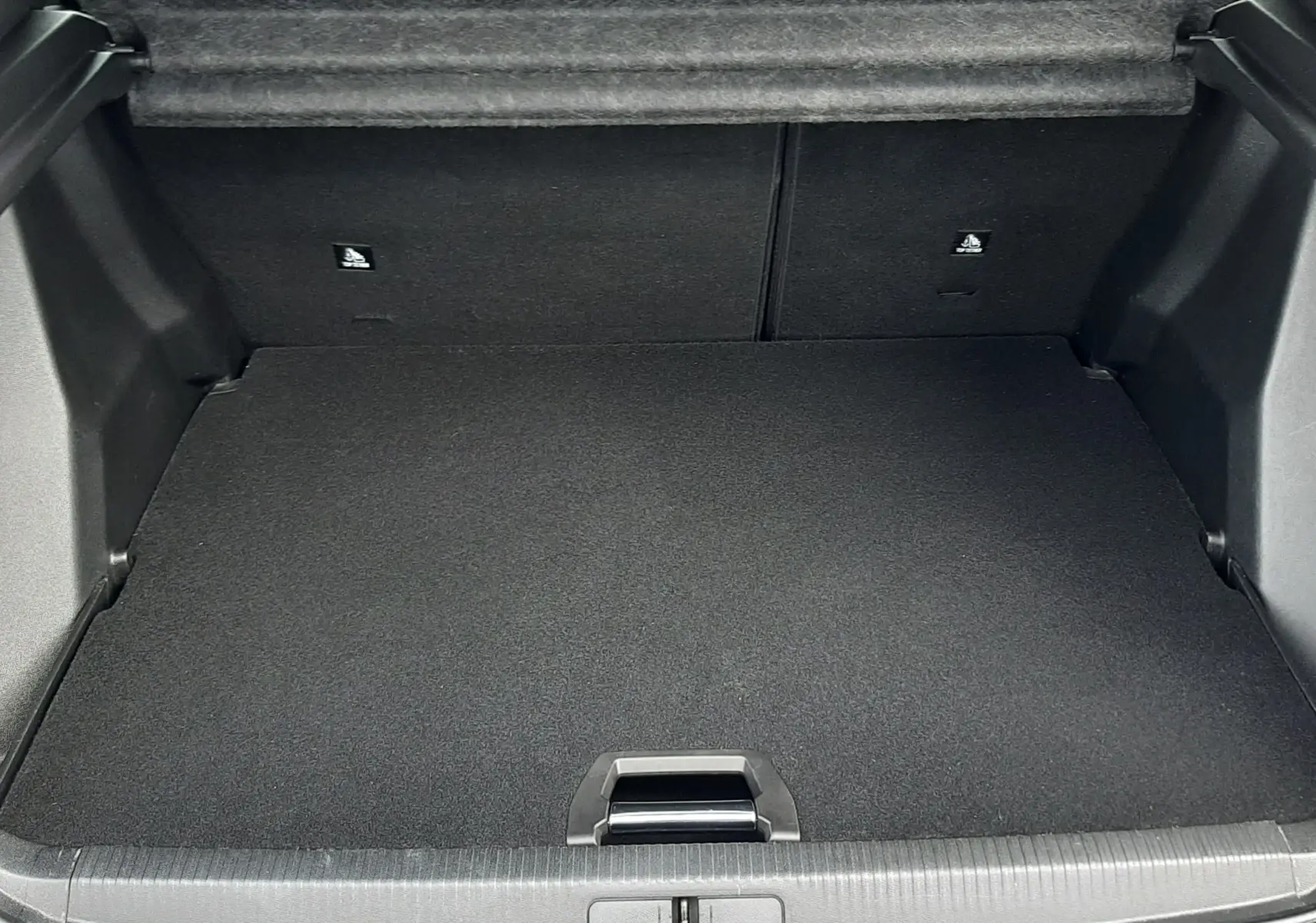 Coffre ouvert vu de l'arrière du Peugeot 2008 blanc, montrant un espace de chargement propre et bien fini.