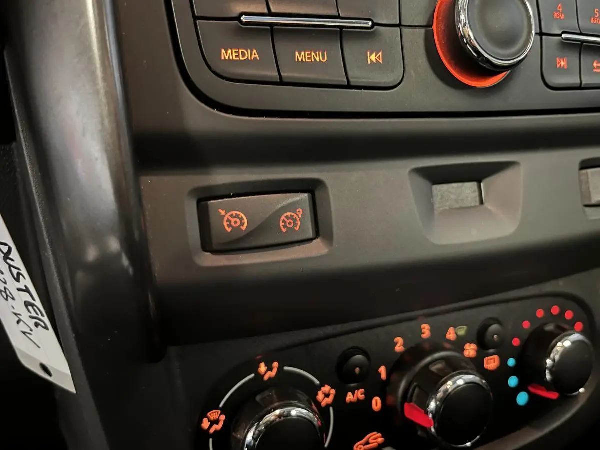 Détail du tableau de bord du Dacia Duster noir 2016 montrant les commandes du régulateur de vitesse et de la climatisation.