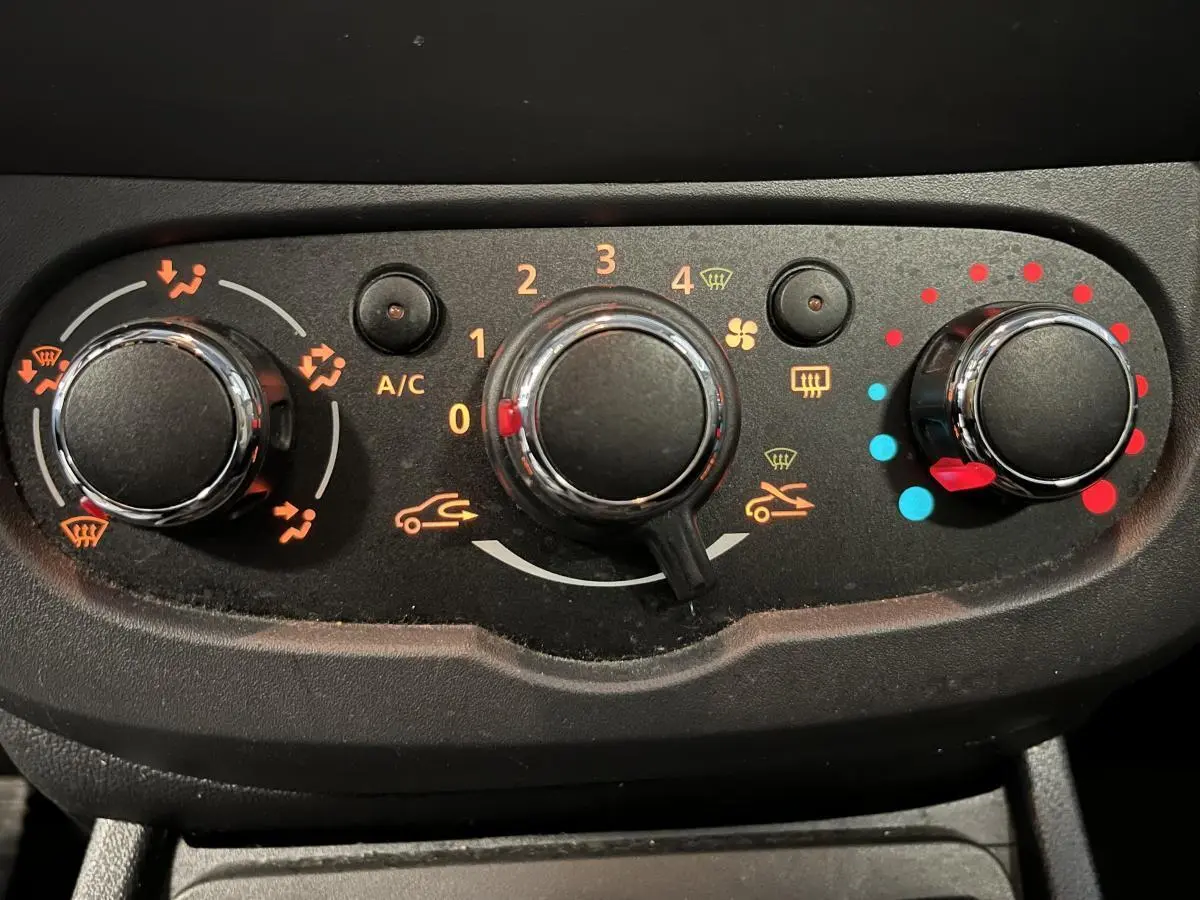 Commandes de climatisation noires avec réglages de température, ventilation et distribution d'air sur Dacia Duster noir 2016.