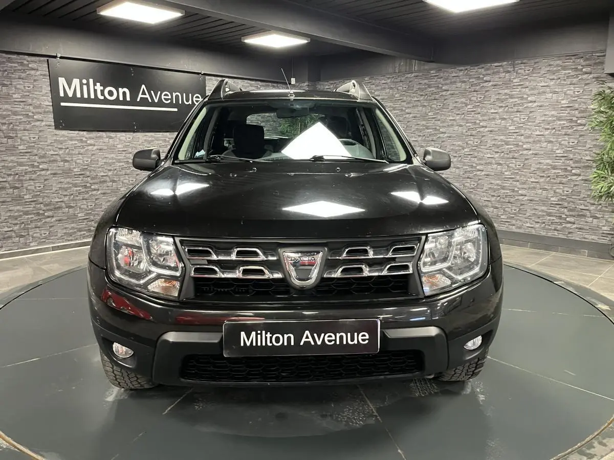 Vue frontale d'un Dacia Duster noir 2016 avec calandre chromée et projecteurs à double optique.