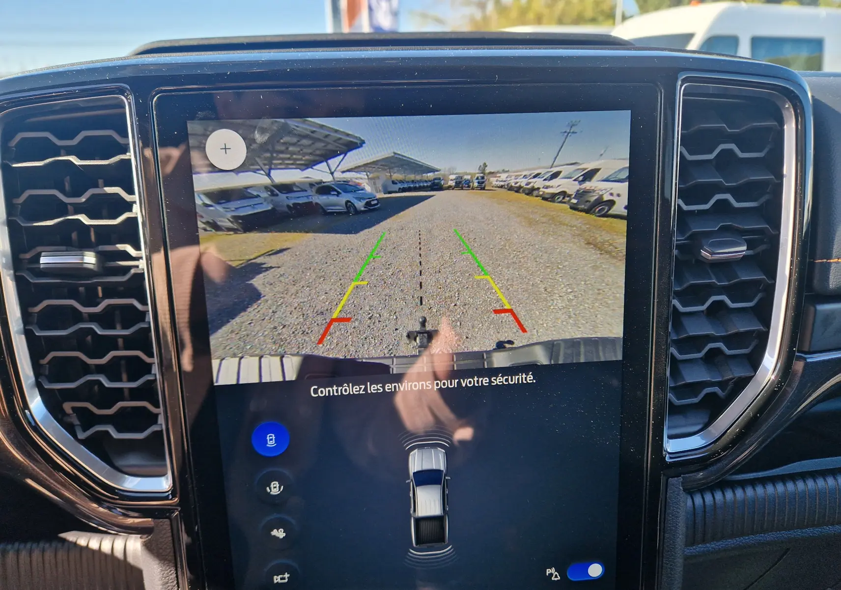 Écran central du Ford Ranger Wildtrak gris Iconic montrant la caméra de recul avec lignes de guidage colorées.