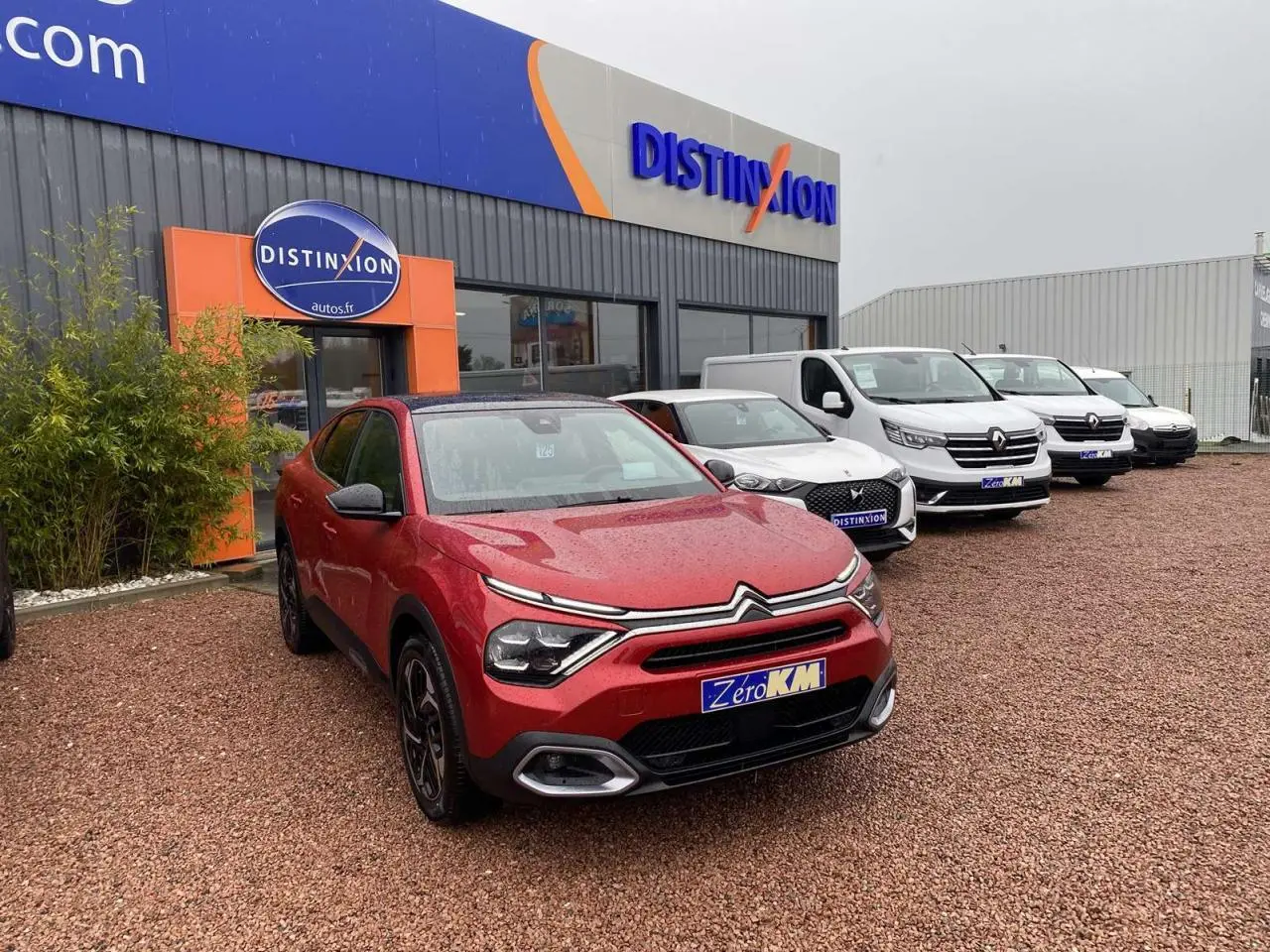 Citroën C4 X rouge Elixir vue 3/4 avant avec toit ouvrant électrique sur parking de concession