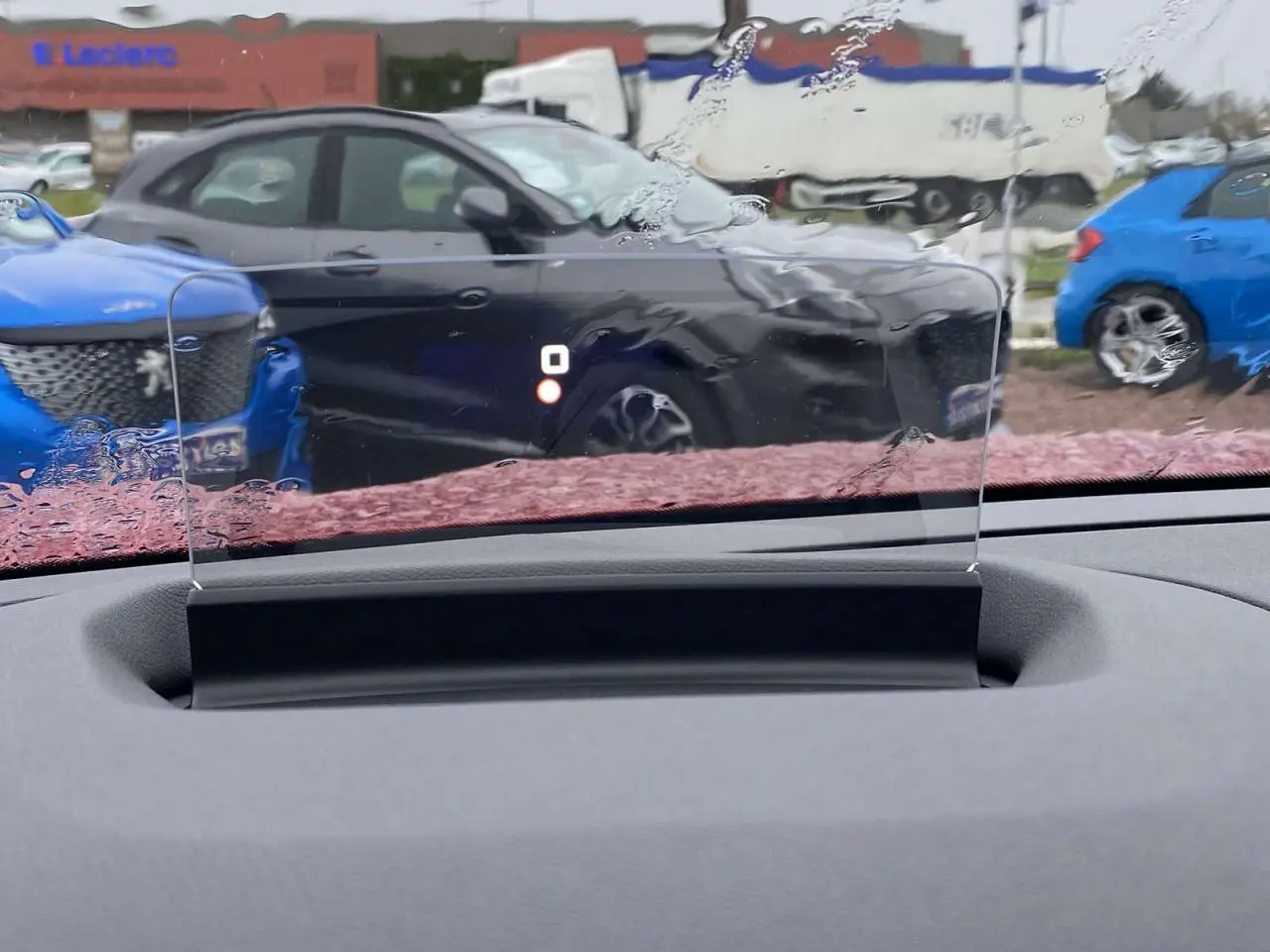 Affichage tête haute transparent du Citroën C4 X rouge Elixir, vue intérieure sur tableau de bord et pare-brise humide.