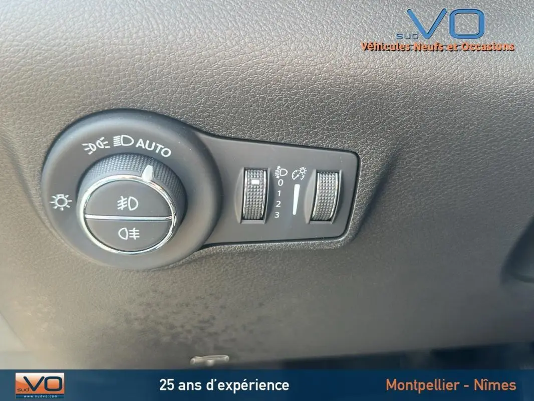 Gros plan sur le bouton de commande des phares du Jeep Compass blanc 2024, avec réglages d'éclairage et pack hiver visible.