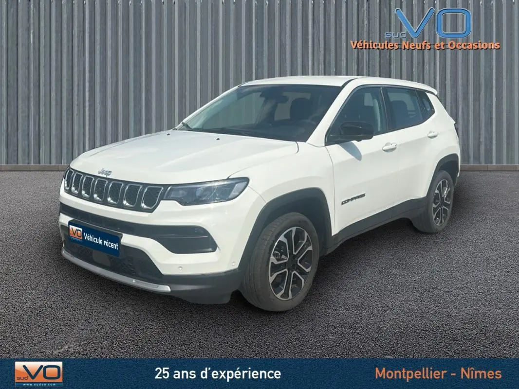 Jeep Compass blanc en 3/4 avant droit, jantes 17 pouces et calandre distinctive, modèle 2024 e-Hybrid Altitude.
