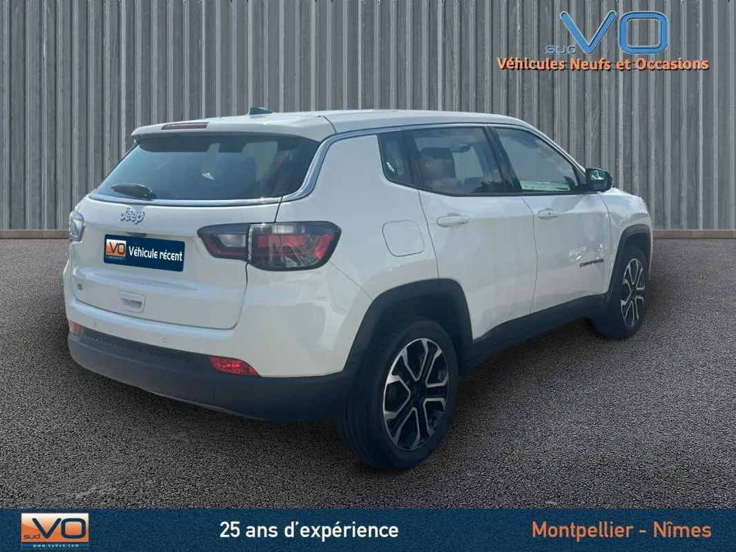 Jeep Compass blanc vue 3/4 arrière droit avec jantes 17 pouces et roue de secours visible sur ce SUV 2024.