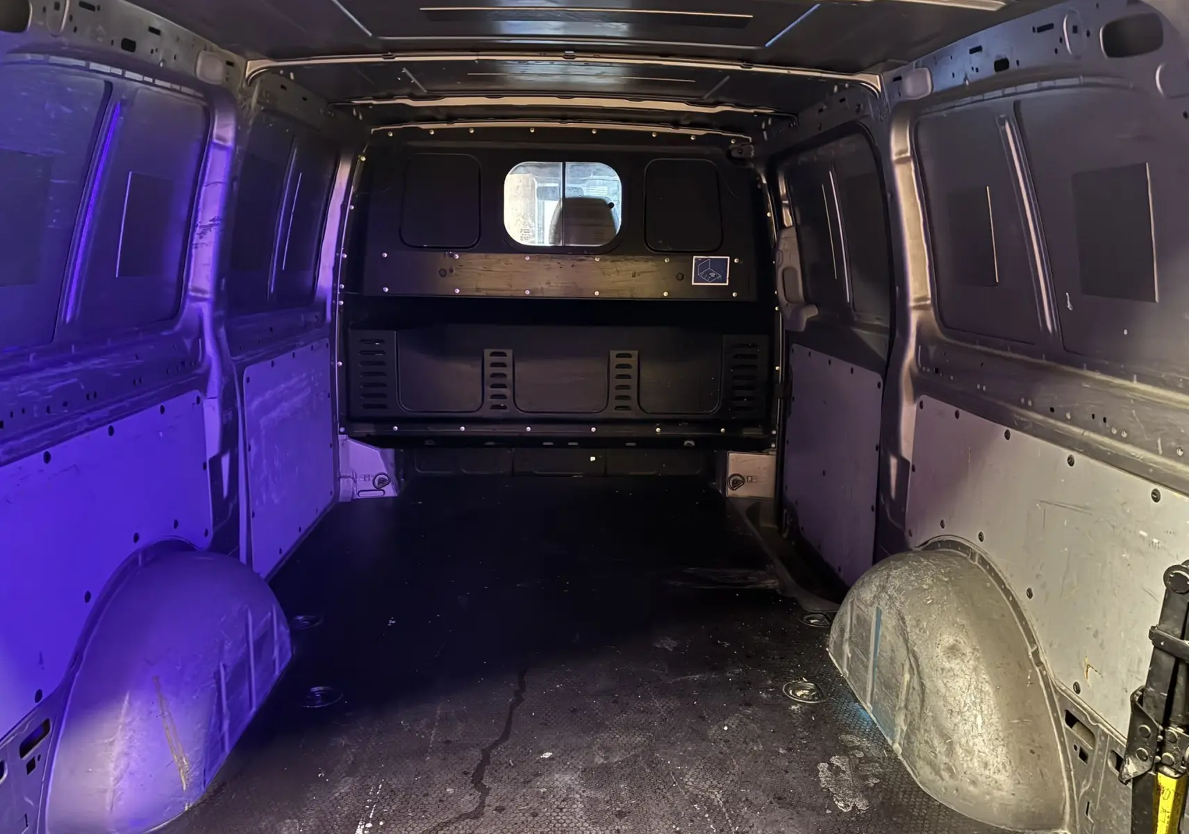 Vue intérieure arrière du fourgon long Mercedes Vito gris 2012, montrant l'espace de chargement vide et les parois métalliques.