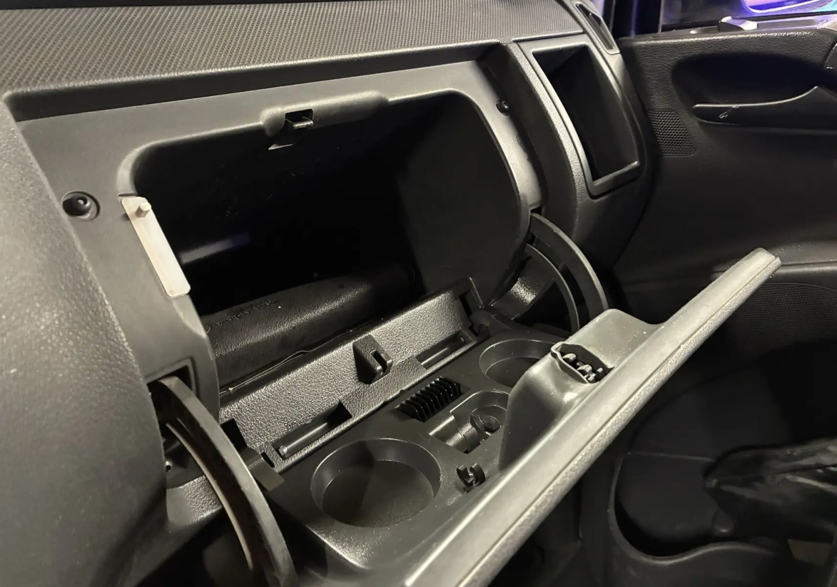 Intérieur noir du Mercedes Vito 2.8 113 CDI 2012, vue sur la boîte à gants ouverte côté passager.