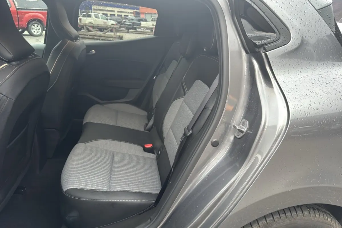 Vue côté droit sur la banquette arrière gris clair et noir de la Renault Clio V TCe 90 Techno Plus gris schiste avec portière ouverte.