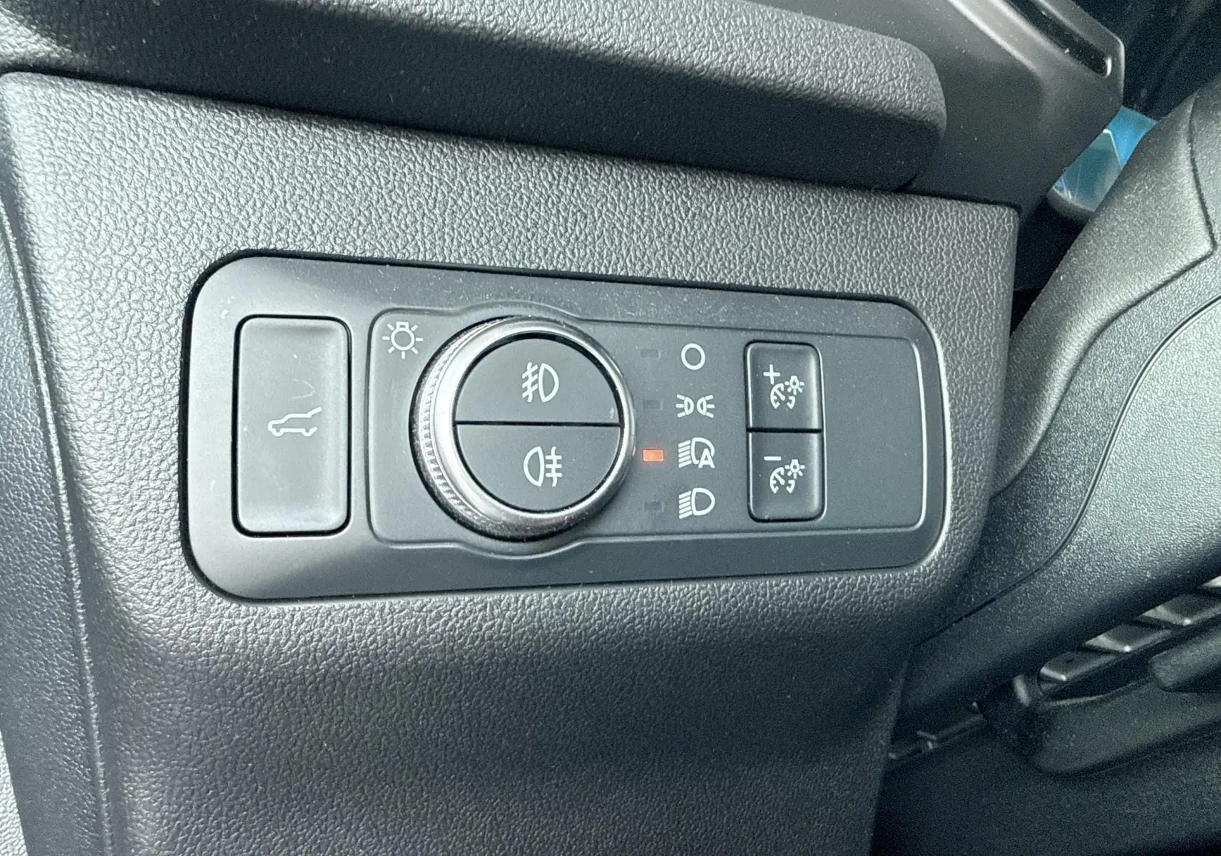 Gros plan sur les commandes d’éclairage et hayon du Ford Kuga 2023, finition ST-Line, intérieur noir.