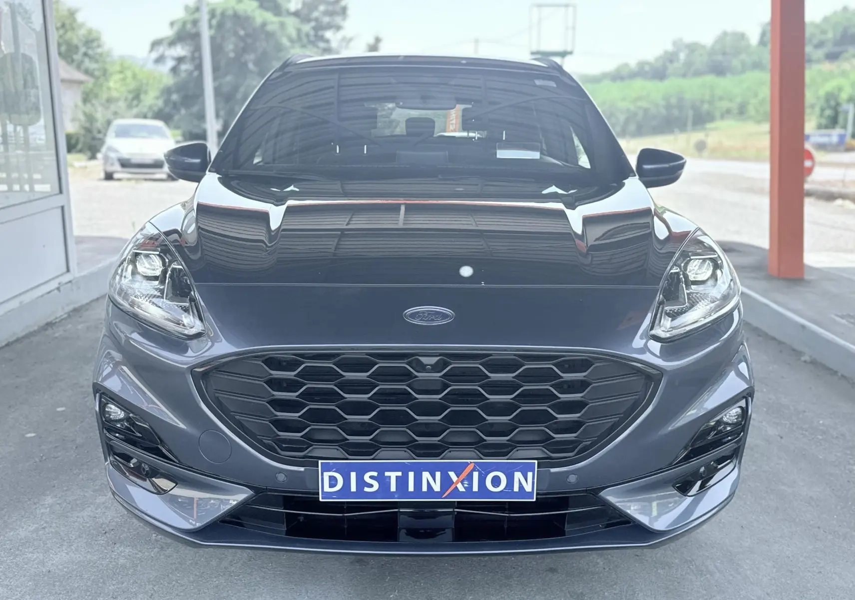 Vue avant centrée d'un Ford Kuga 2.0 EcoBlue 120 BVA ST-Line X gris métallisé avec calandre hexagonale et phares LED.