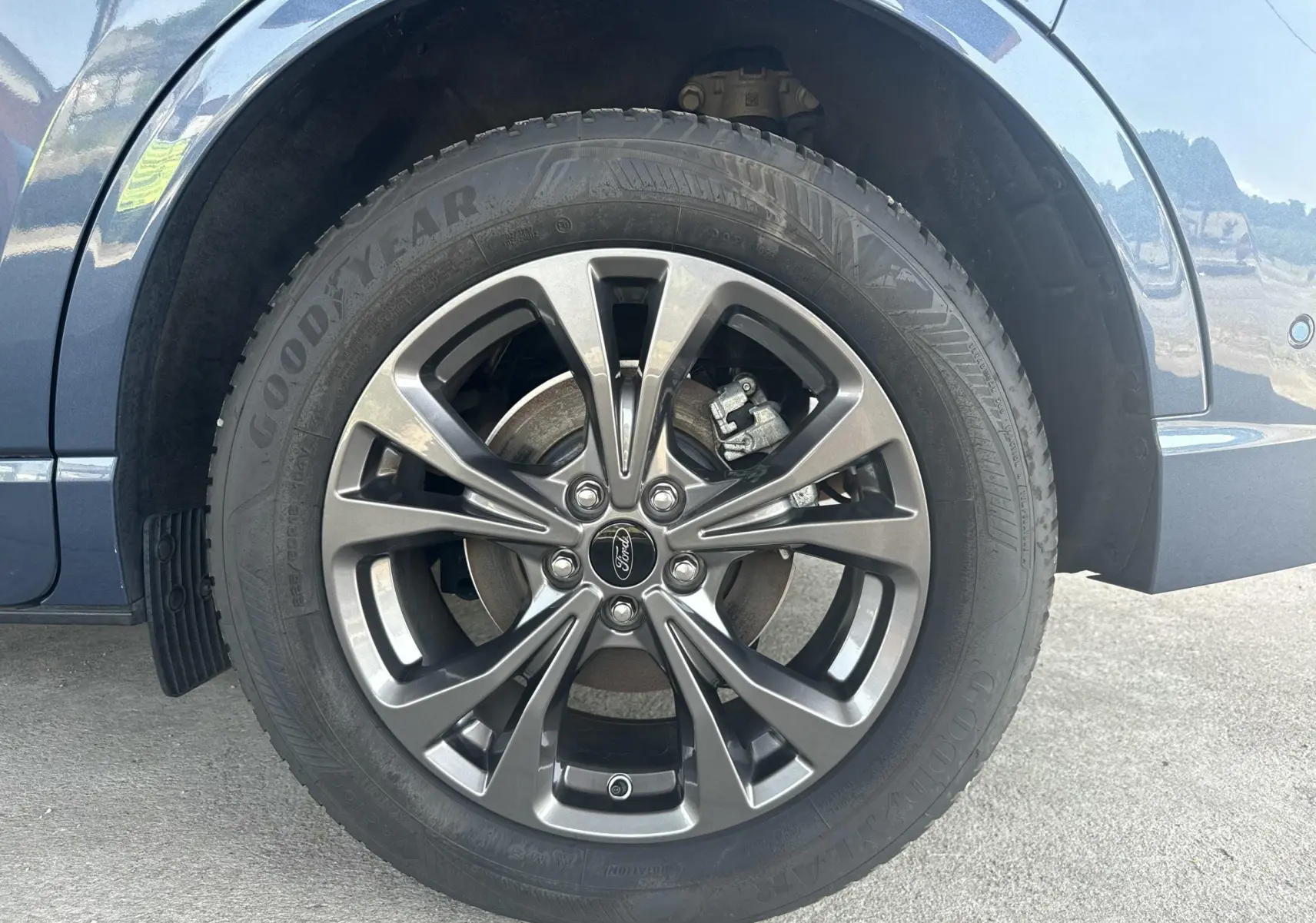 Gros plan sur la roue avant droite du Ford Kuga bleu azur, avec jante alliage 18 pouces finition ST-Line.