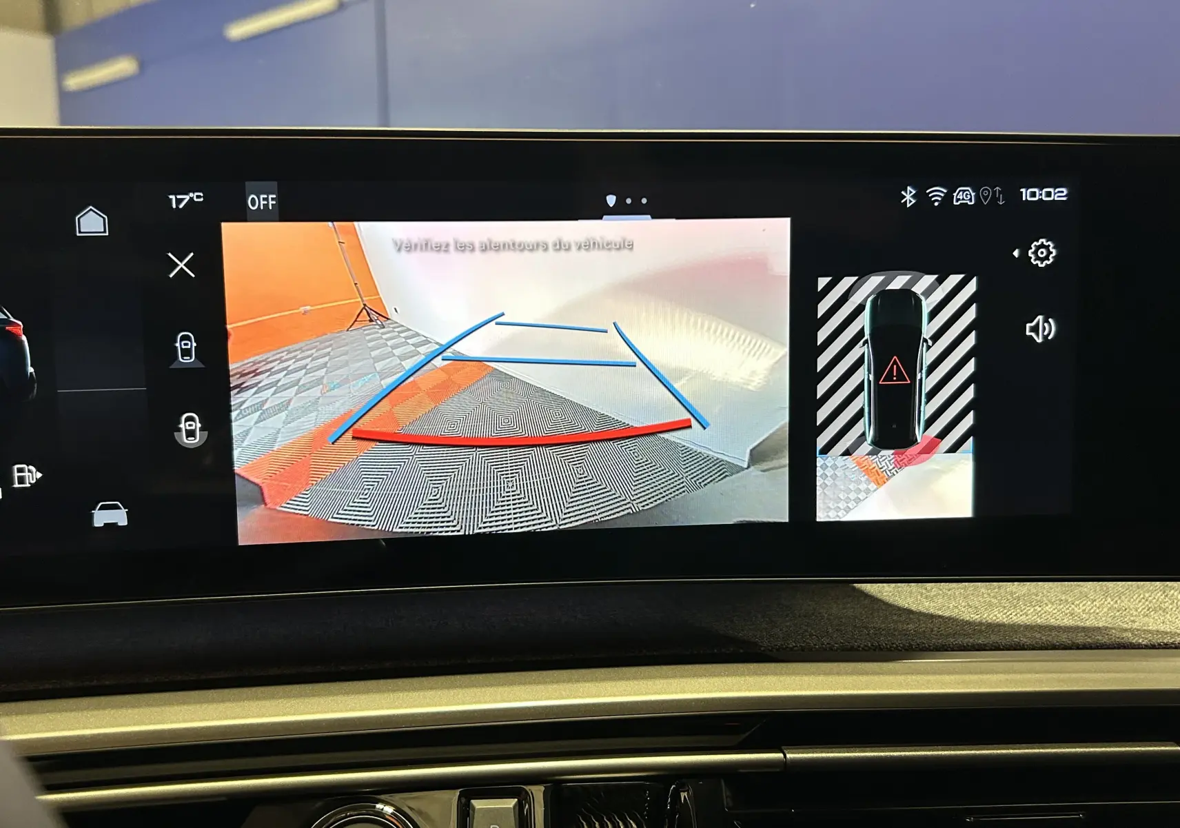 Écran de caméra de recul affichant l’aide au stationnement sur Peugeot 5008 Hybrid blanc, vue intérieure tableau de bord.