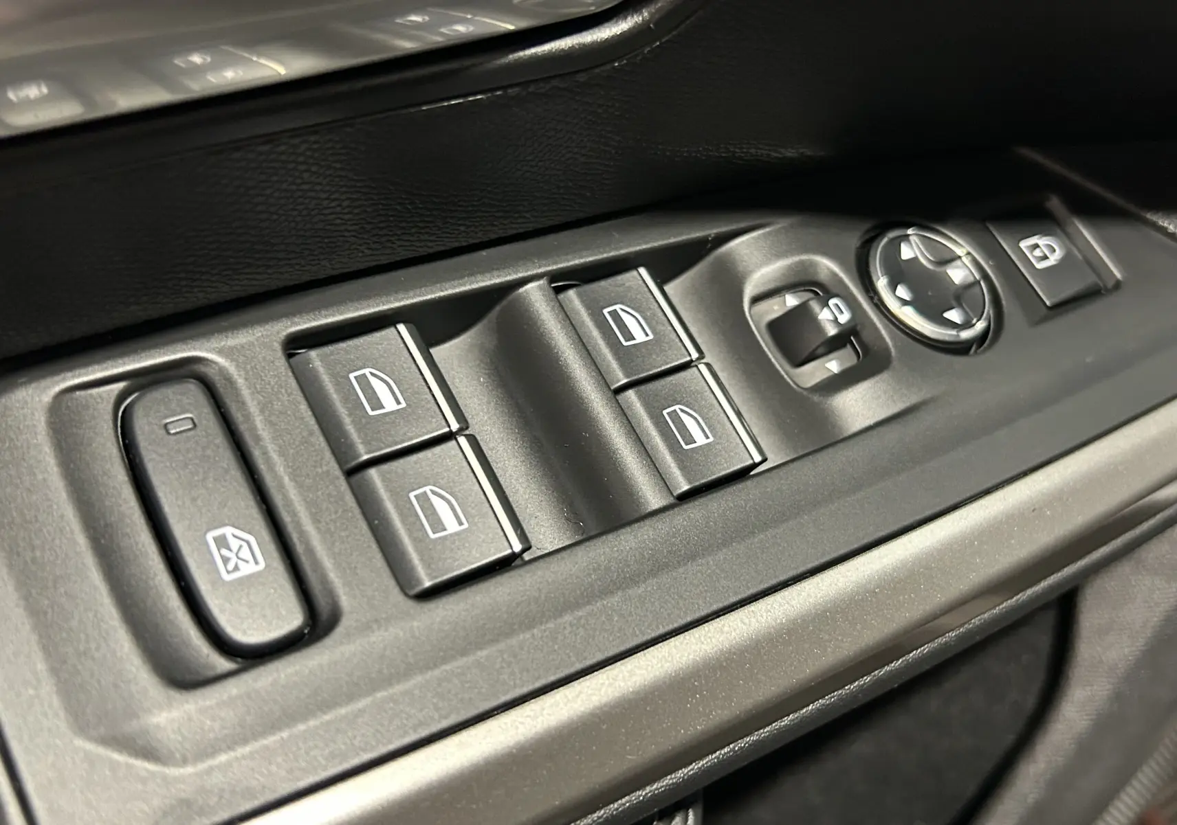 Gros plan sur les commandes de lève-vitres et réglages des rétroviseurs côté conducteur d’un Peugeot 5008 blanc.