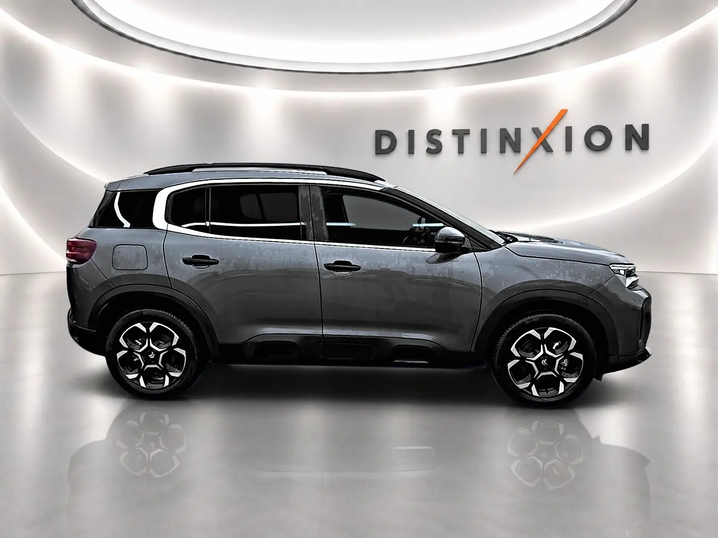 Profil droit du Citroën C5 Aircross gris 2025 avec jantes alu et barres de toit en studio lumineux.