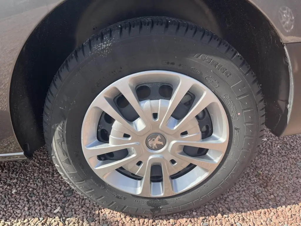 Gros plan sur la roue avant droite du Peugeot Expert Fourgon gris platinium, avec jante en alliage et logo lion central.