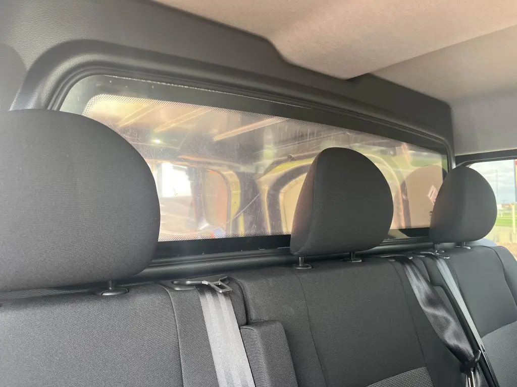 Banquette arrière noire avec appuie-têtes et cloison plexiglass du Peugeot Expert Fourgon gris platinium 2023.