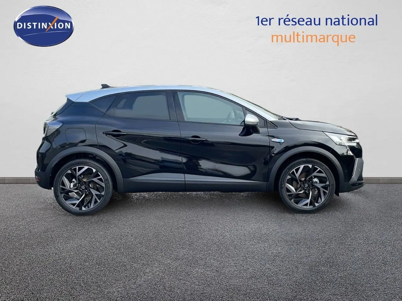 Profil côté gauche du Renault Captur E-Tech hybride 2025 noir étoile avec toit gris et jantes noires bicolores.