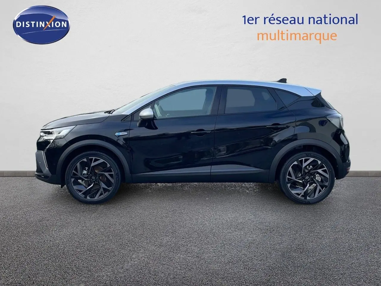 Profil côté gauche du Renault Captur E-Tech hybride 2025 noir étoile avec toit gris et jantes noires biton.