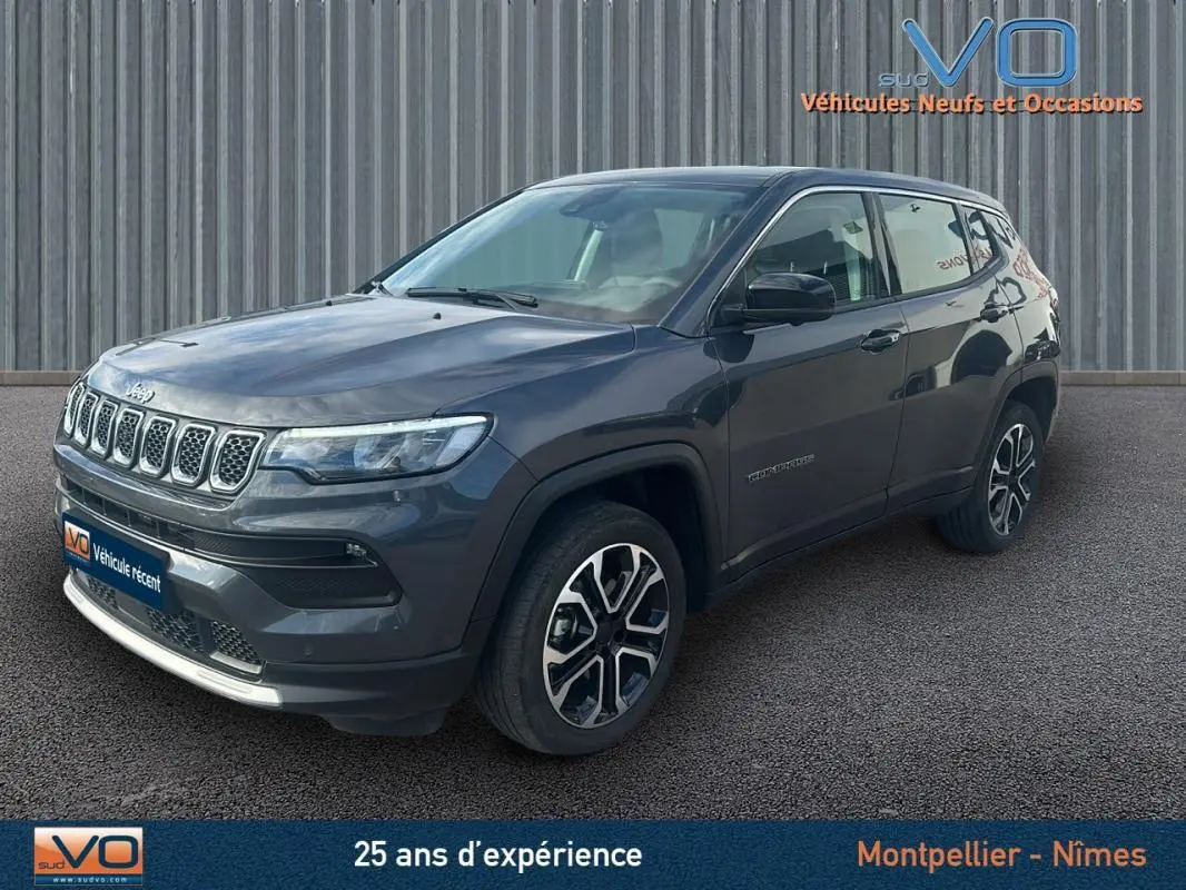 Vue 3/4 avant droit d'un Jeep Compass gris 2024 avec calandre distinctive et jantes modernes.