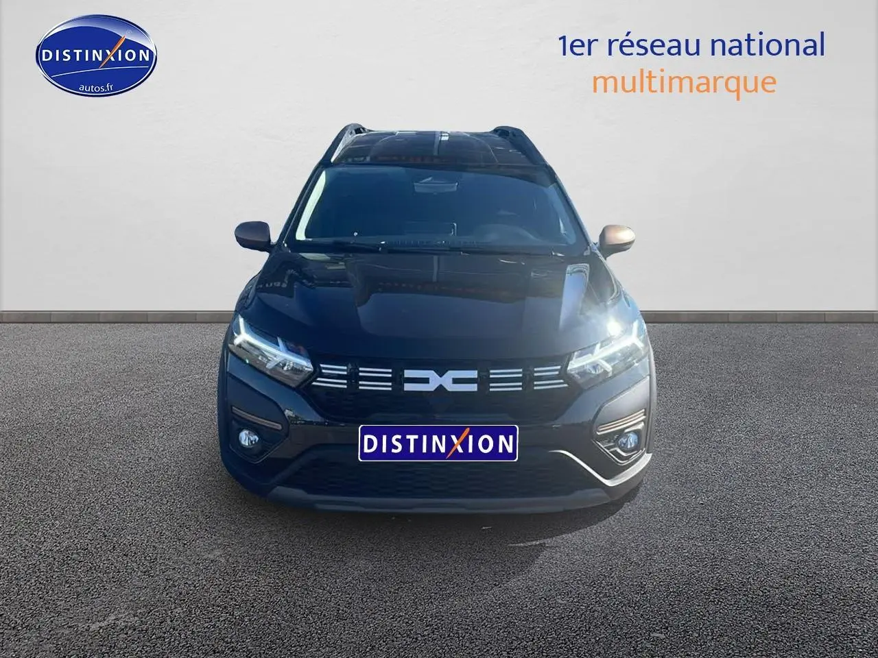 Vue frontale d'un Dacia Jogger 1.6 hybrid 140 noir nacré avec phares LED allumés sur fond neutre.