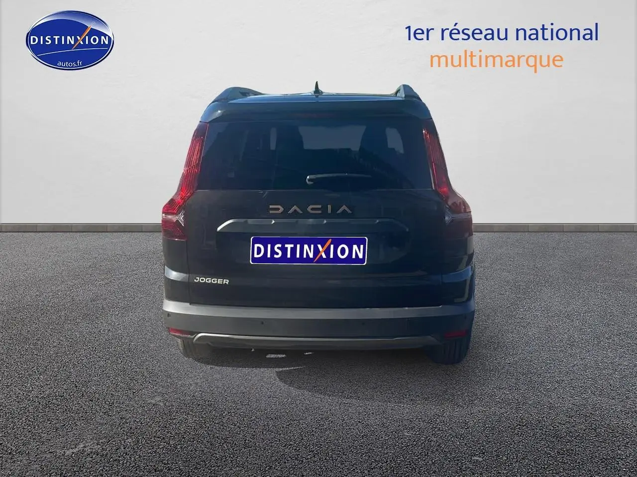 Vue arrière d'un Dacia Jogger noir nacré 2024 avec feux arrière verticaux et barres de toit visibles.