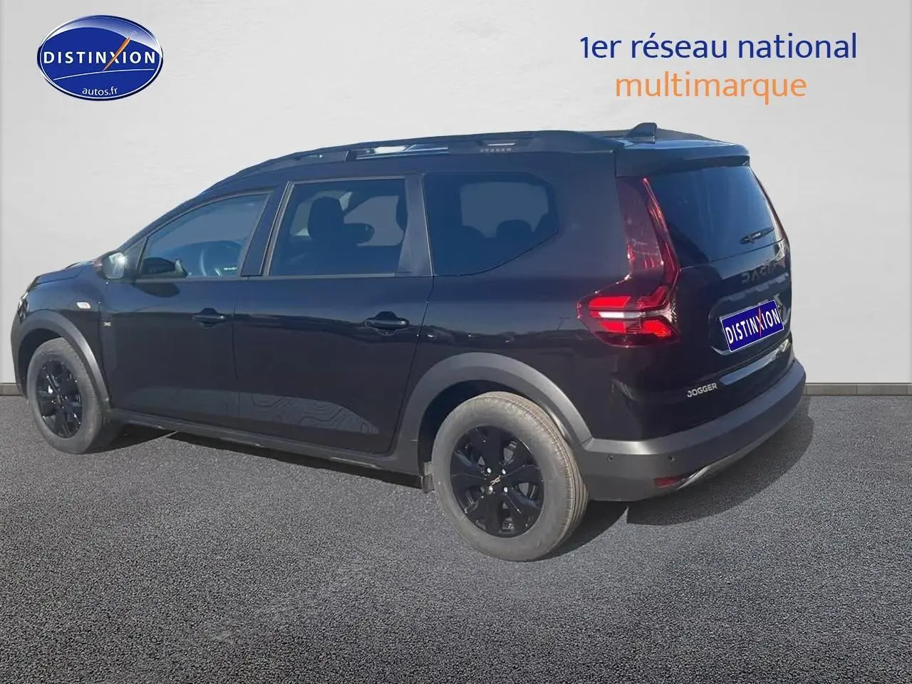 Vue 3/4 arrière droite d'un Dacia Jogger noir nacré avec barres de toit et jantes noires.