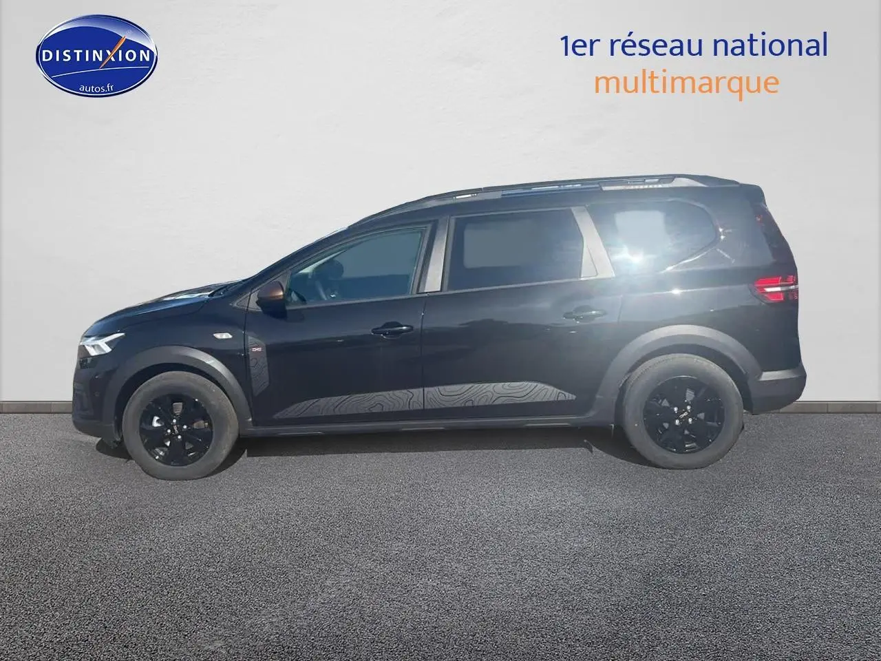 Vue latérale droite d'un Dacia Jogger 1.6 hybrid 140 extrême noir nacré avec jantes noires et barres de toit.