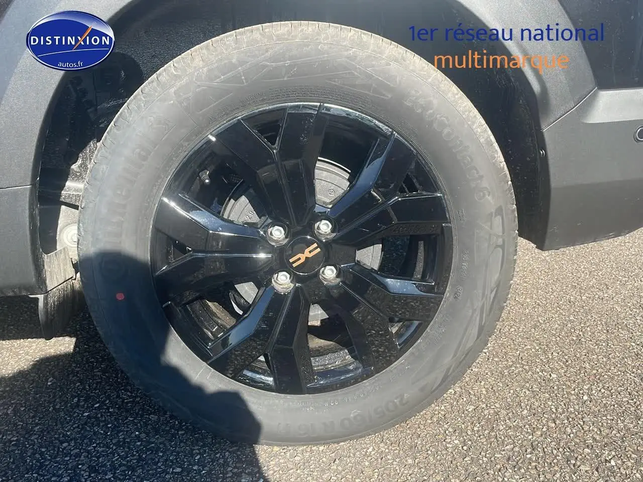 Gros plan sur la jante alu noire brillante côté gauche du Dacia Jogger 1.6 hybrid 140 Extreme noir nacré 2024.