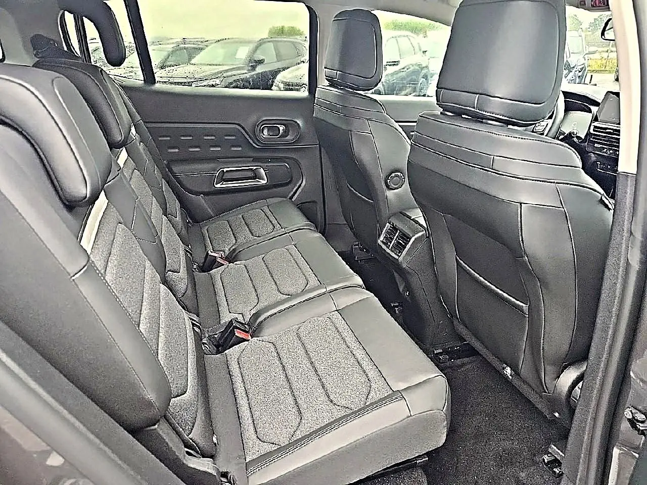 Vue intérieure côté gauche sur la deuxième rangée de sièges gris en cuir et tissu du Citroën C5 Aircross 2025.