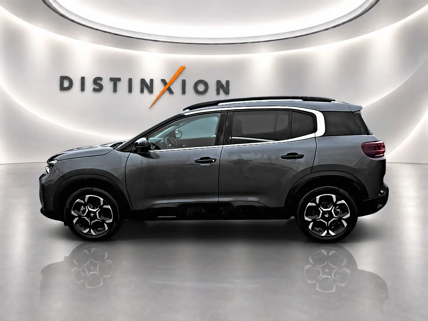 Vue latérale droite d'un Citroën C5 Aircross gris 2025 avec jantes alu et barres de toit noires.