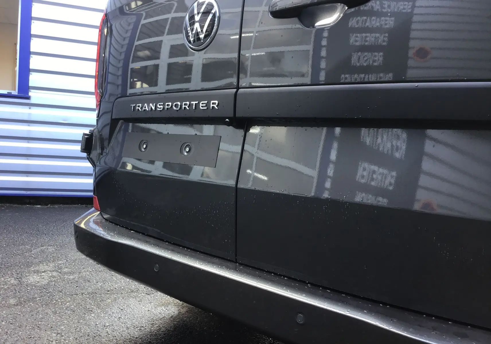 Gros plan sur l'arrière gris anthracite du Volkswagen Transporter ProCab 2025 avec logo VW et feux LED visibles.
