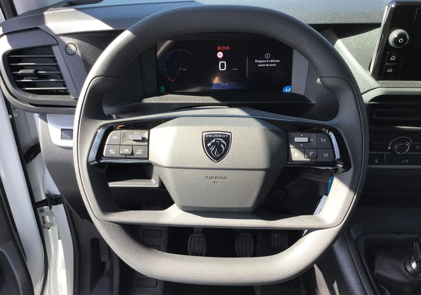 Vue rapprochée du volant et du tableau de bord du Peugeot Expert Fourgon blanc 2025 avec commandes intégrées et boîte manuelle.