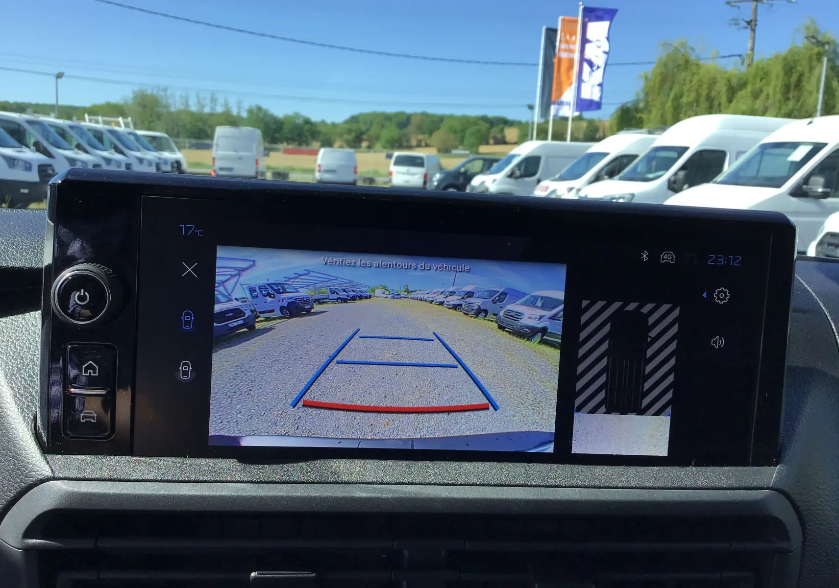 Écran de caméra de recul du Peugeot Expert Fourgon blanc, vue arrière avec lignes de guidage et parking de véhicules blancs.