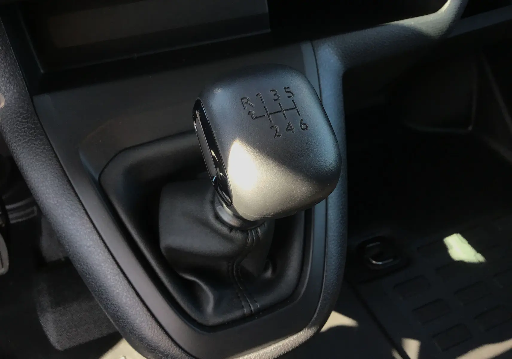 Le levier de vitesses manuel noir en gros plan dans l'habitacle du Peugeot Expert Fourgon blanc 2025.