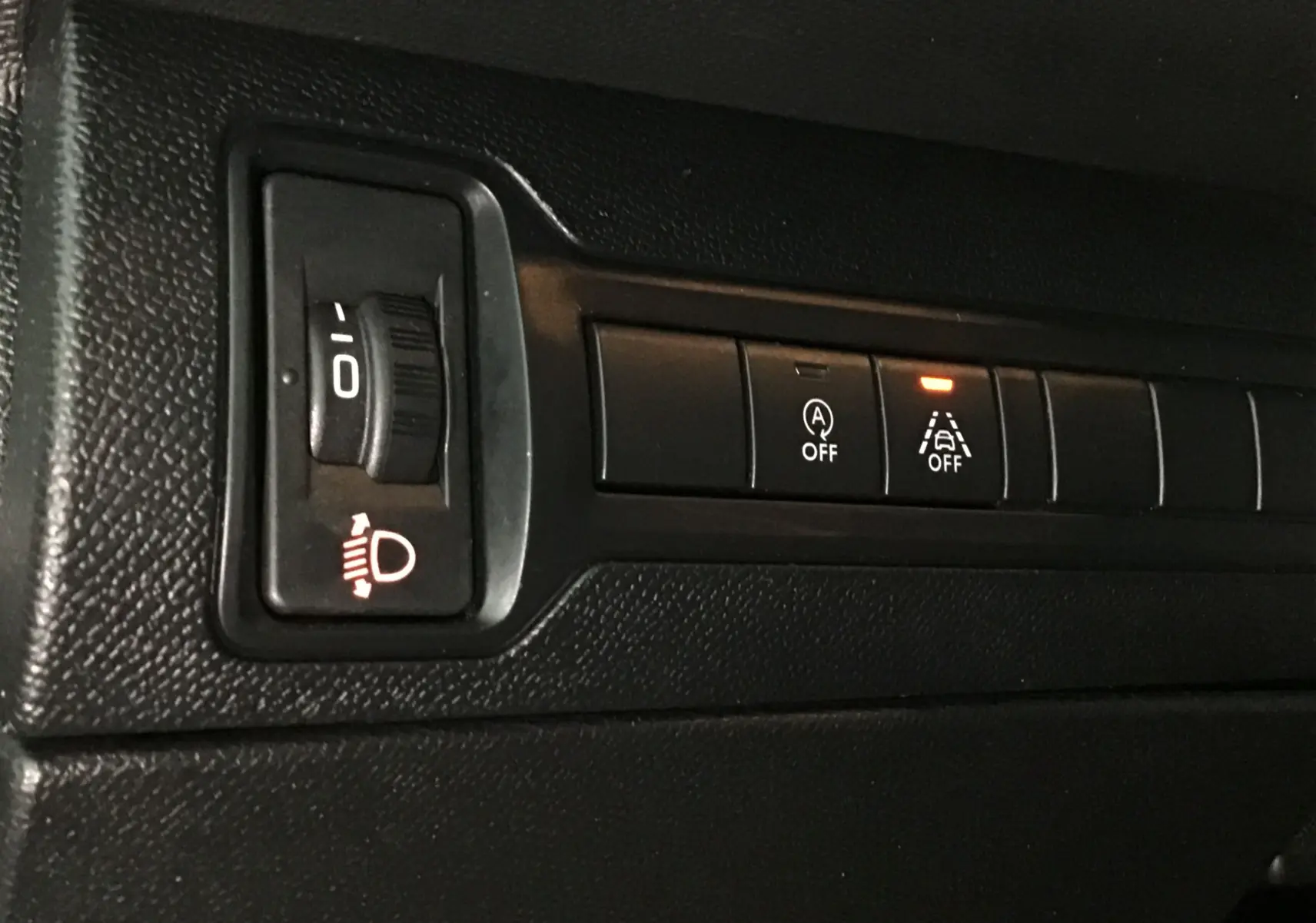 Gros plan sur les commandes noires du tableau de bord du Peugeot 308 SW blanc, avec témoin d'alerte allumé.