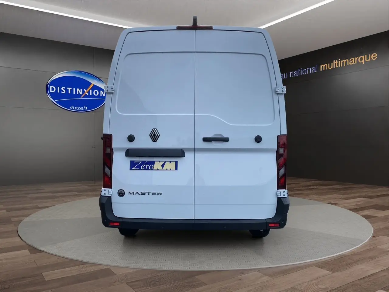 Vue arrière d'un Renault Master blanc avec portes tôlées et logo Zero KM visible en showroom.