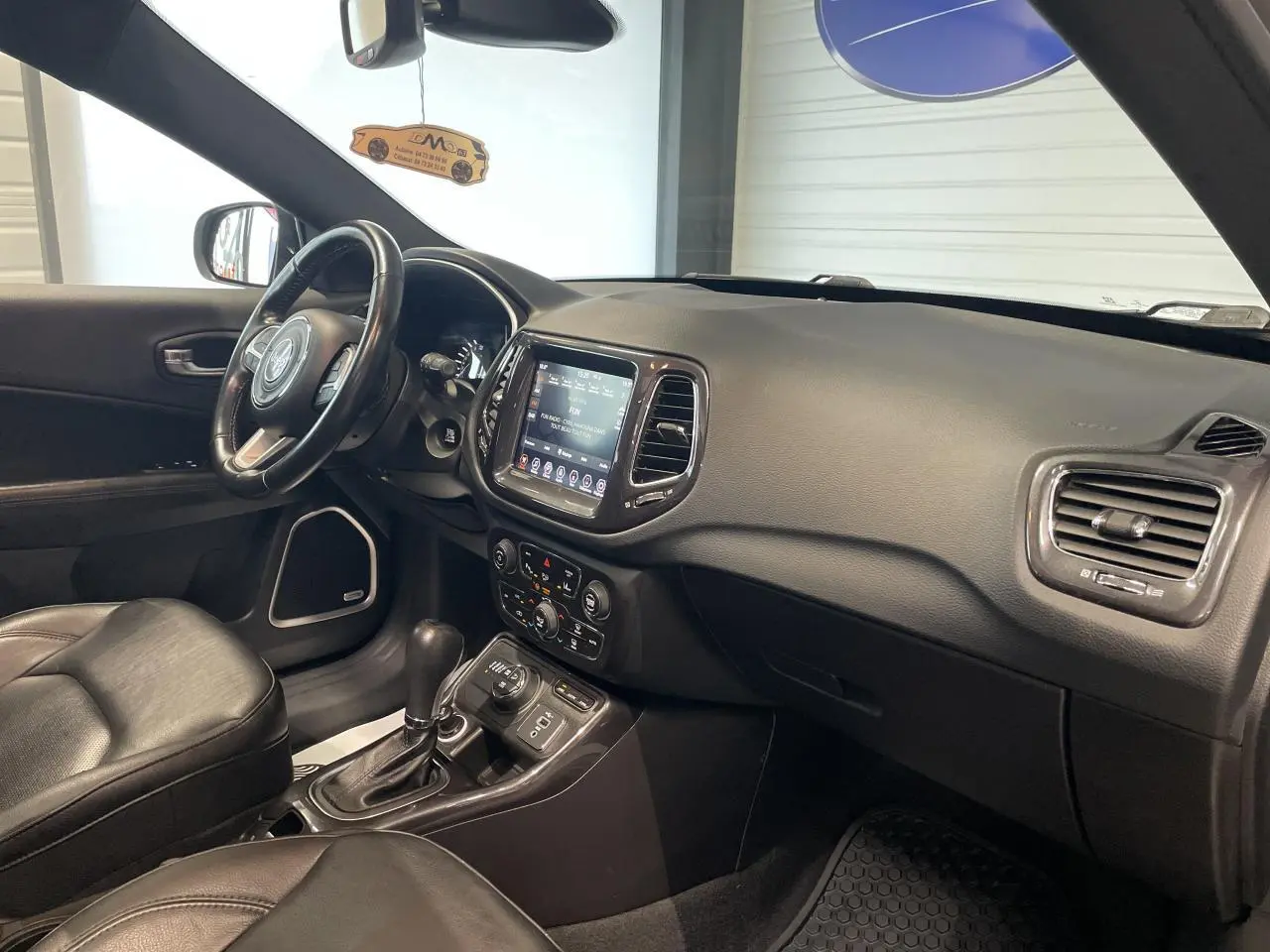 Intérieur noir cuir du Jeep Compass 2021, vue côté passager avec tableau de bord et écran tactile central.