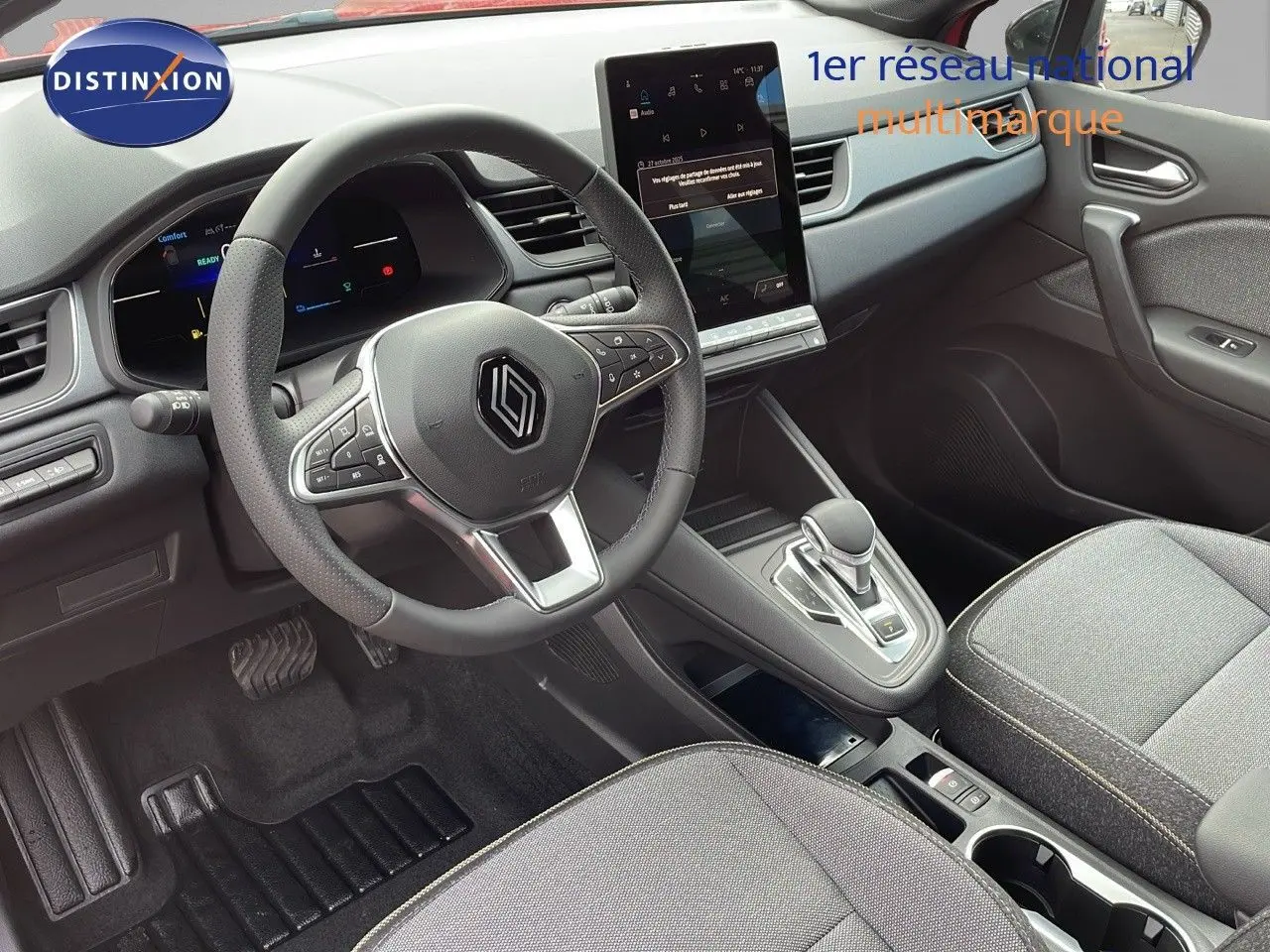 Vue intérieure avant du Renault Captur E-Tech hybride 2025, volant multifonction et écran tactile vertical au centre.