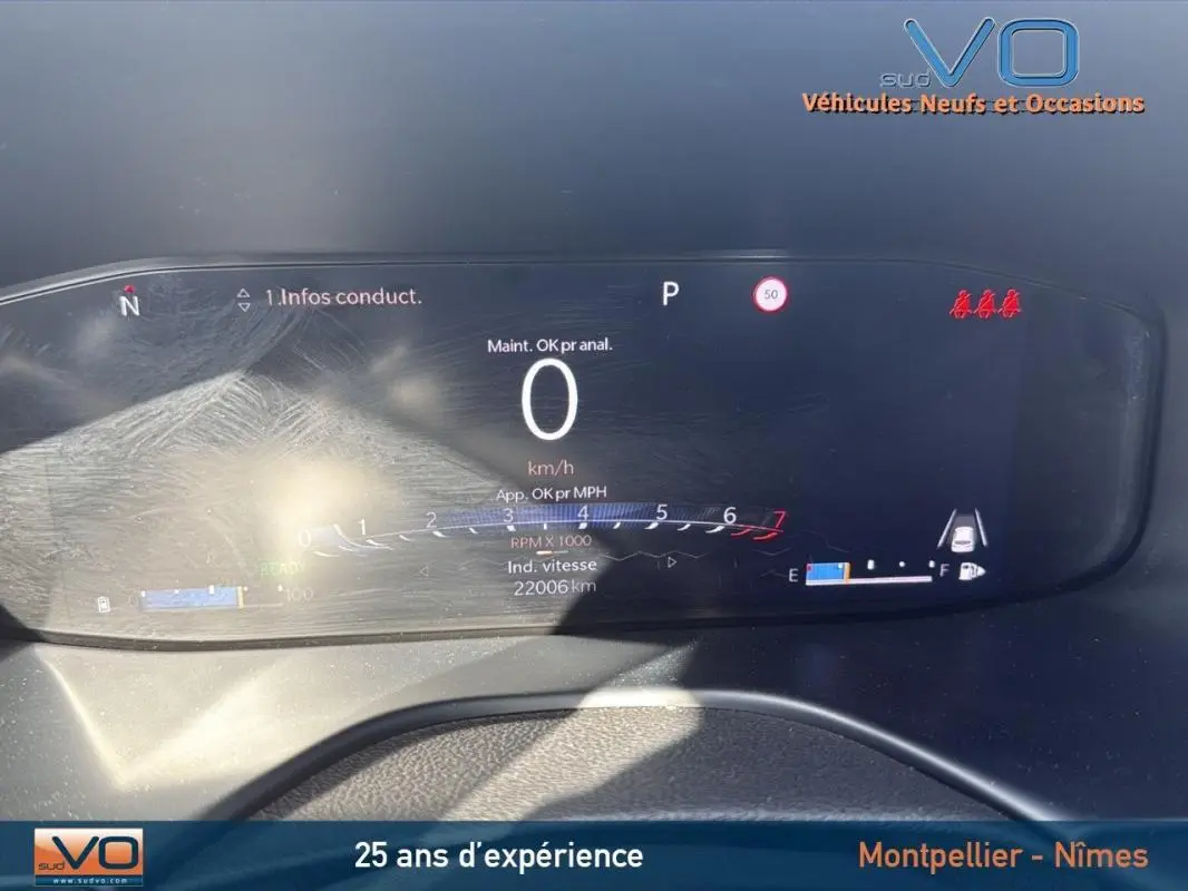 Tableau de bord numérique du Jeep Compass blanc 2024 montrant la vitesse à 0 km/h et l'indicateur de carburant.