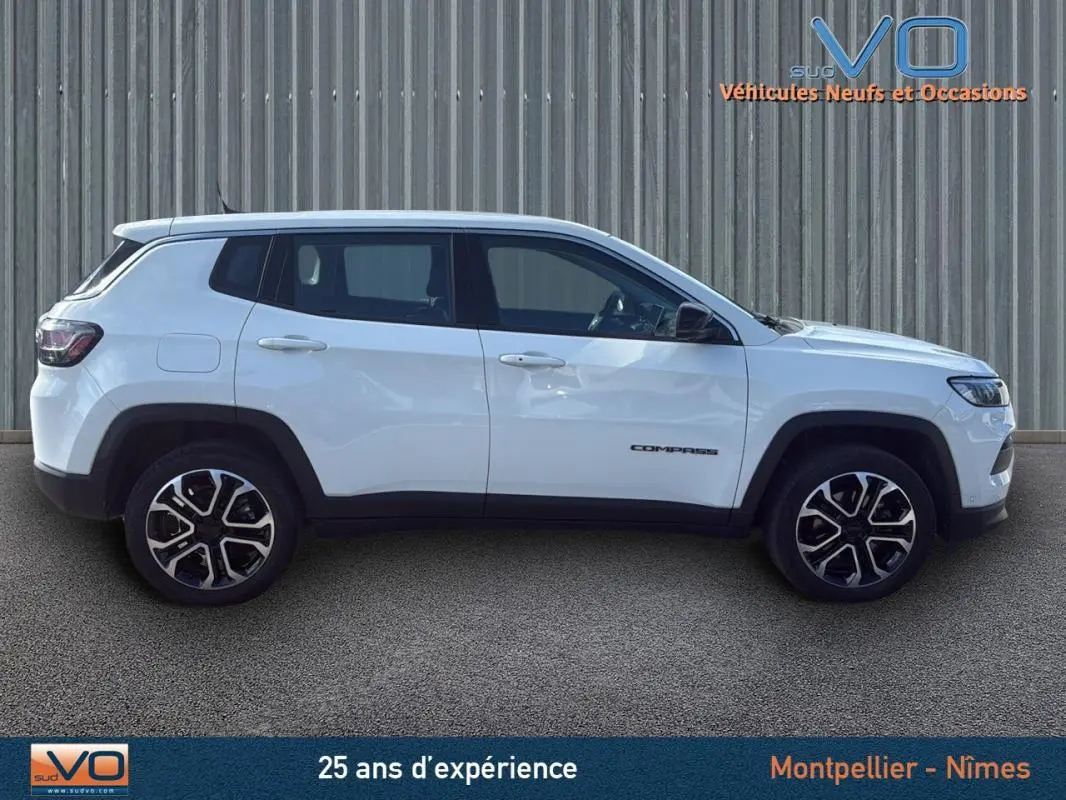 Vue latérale droite du Jeep Compass blanc 2024 avec jantes alliage 18 pouces et logo visible sur la porte
