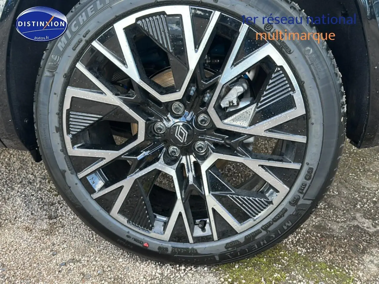 Gros plan sur la jante alliage 20 pouces noire et argentée du Renault Austral bleu, avec logo Renault au centre.